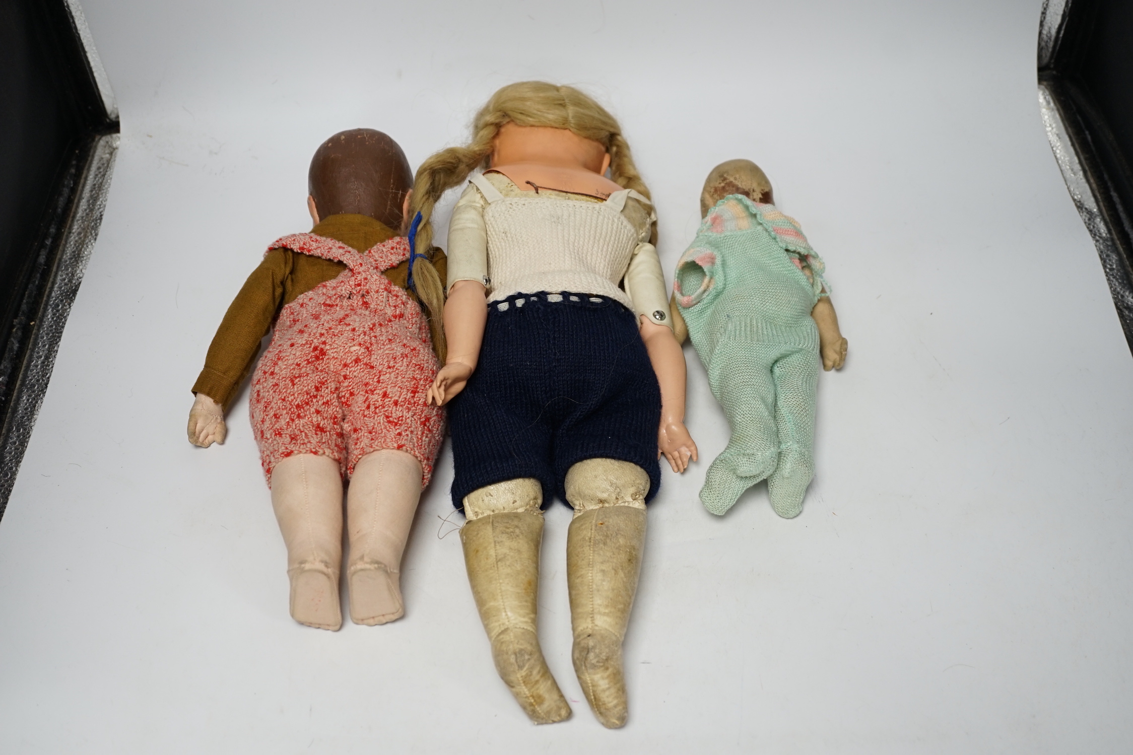 Three dolls including one by Kathe Kruse, original shirt, height 36cm, nose rubbed, one cloth doll, one celluloid with turtle mark eyes in head, height 46cm, original wig